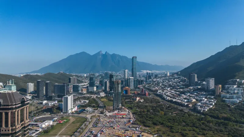Vista aérea de Monterrey de día, con las torres de Valle Oriente y el Cerro de la Silla al fondo