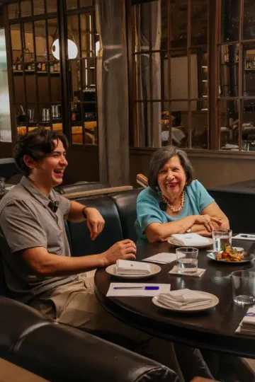 Dos personas riendo en una mesa de Meza