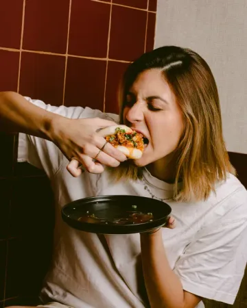 Persona comiendo un bao de Nooda